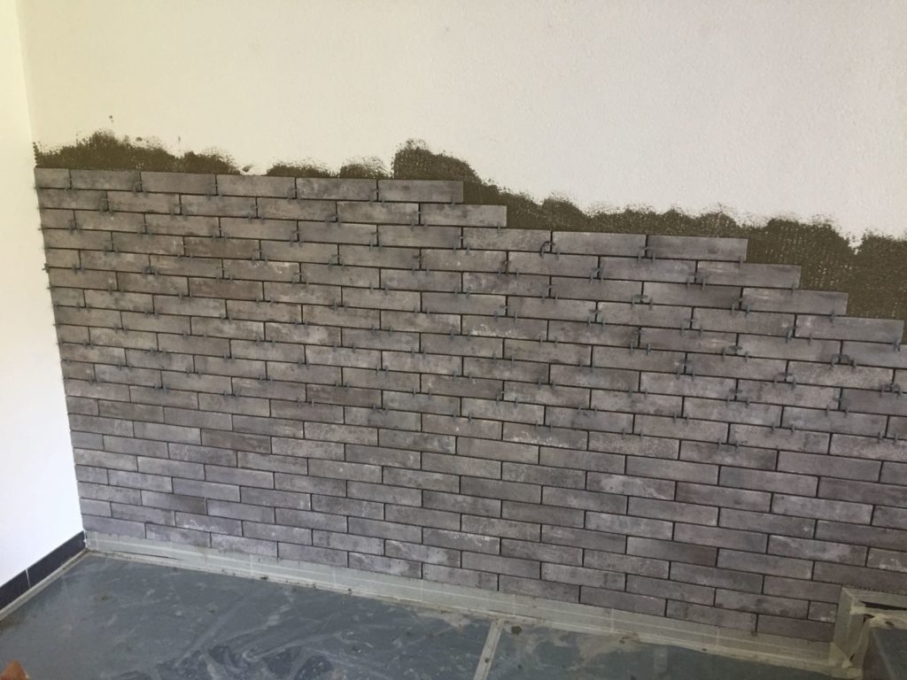 Pose de parement en pierre sur une face de mur d'un salon