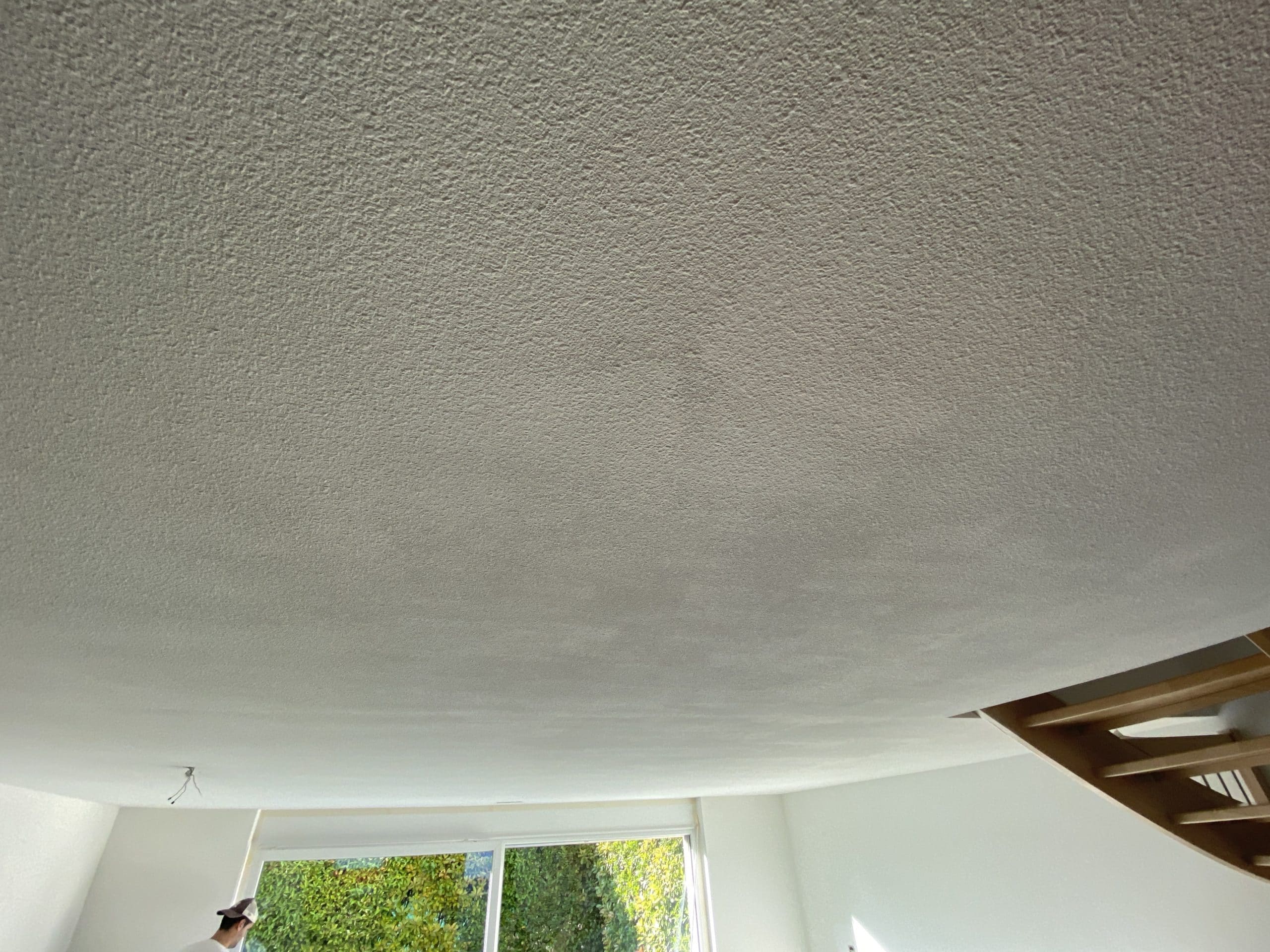 Le plafond en crépi gouttelette présente de nombreuses traces (mauvaise qualité de peinture et mauvaise qualité d'exécution))